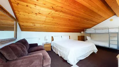 a bedroom with a bed and a couch at Snowflower #20 condo in Mammoth Lakes
