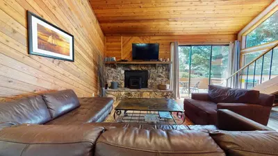 a living room with a leather couch and a fireplace at Snowflower #20 condo in Mammoth Lakes