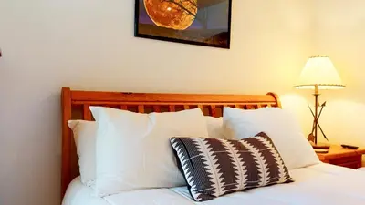 a bed with white pillows and a picture on the wall at Snowcreek #840 condo in Mammoth Lakes