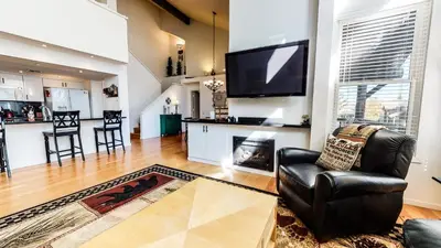 a living room with a black leather chair and a fireplace at Snowcreek #840 condo in Mammoth Lakes