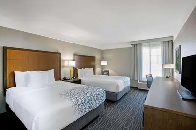 a hotel room with two beds and a flat screen tv at La Quinta by Wyndham Manteca - Ripon in Ripon