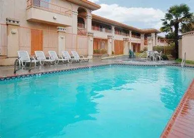 a large pool with blue water in front of a building at Baymont by Wyndham Manteca in Manteca