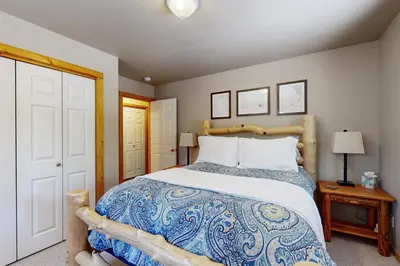 a bedroom with a large bed with a wooden headboard at Sugar Pine Haus in Tahoma