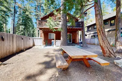 a wooden picnic table sitting in front of a house at Sugar Pine Haus in Tahoma