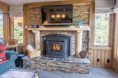 a fireplace with a television on top of it at Brand New Listing! 5 minute walk to Canyon Lodge! Newly Updated Two-Bed, Two-Bath, Mountainback #14 in Mammoth Lakes