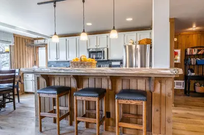 a kitchen with a large wooden counter with stools at Brand New Listing! 5 minute walk to Canyon Lodge! Newly Updated Two-Bed, Two-Bath, Mountainback #14 in Mammoth Lakes