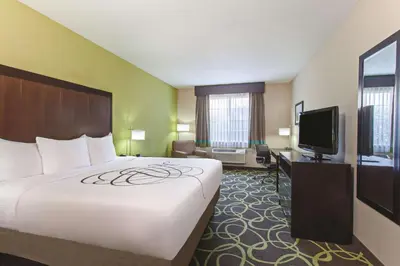 a hotel room with a large bed and a flat screen tv at La Quinta by Wyndham Los Banos in Los Banos
