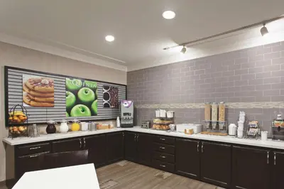 a kitchen with black cabinets and a counter top at La Quinta by Wyndham Los Banos in Los Banos