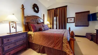 a bedroom with a bed and a dresser with a lamp at Juniper Crest #24 townhouse in Mammoth Lakes