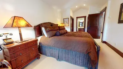 a bedroom with a bed and a lamp on a dresser at Juniper Crest #24 townhouse in Mammoth Lakes