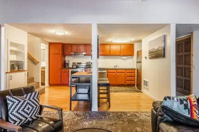a living room with a kitchen with orange cabinets at New Listing Updated 1 Bed and Loft 2 Full Bath La Residence IV N7 Sleeps 4 and Steps to Free Shuttle in Mammoth Lakes