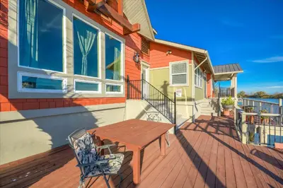 a wooden deck with a wooden table and a bench at Year-round fishing, boating, birding, 1 hr from SF in Walnut Grove