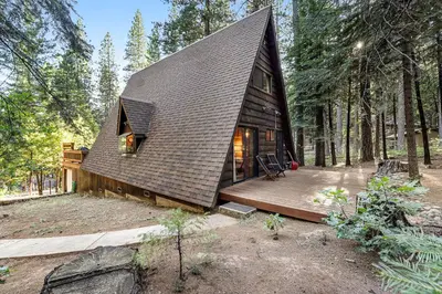 a small cabin in the woods with a wooden deck at Heavenly Daze in Arnold