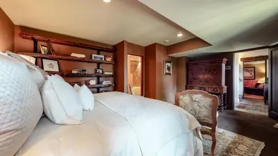 a bedroom with a white bed and a chair at Juniper Ridge #16 home in Mammoth Lakes