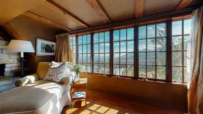 a bedroom with a bed and large windows at Juniper Ridge #16 home in Mammoth Lakes