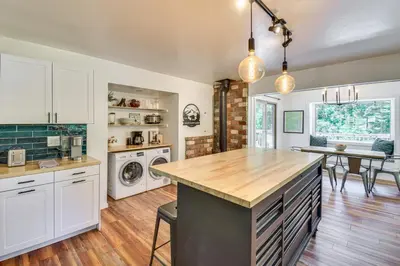 a kitchen with white cabinets and a wooden counter top at Cozy Retreat with Deck about 2 Mi to Pinecrest Lake! in Strawberry