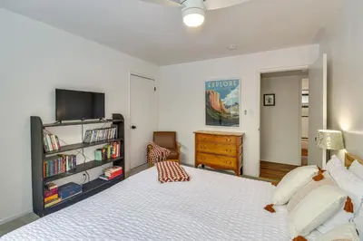 a bedroom with a large bed and a tv at Cozy Retreat with Deck about 2 Mi to Pinecrest Lake! in Strawberry