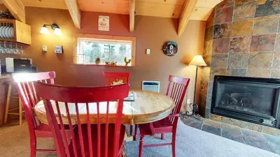 a dining room with a table and chairs and a fireplace at Mammoth View Villas #3 condo in Mammoth Lakes