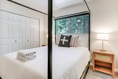 a bedroom with a white bed with a window at Arnold Family Cabin with Hot Tub, Arcade and Deck in Arnold
