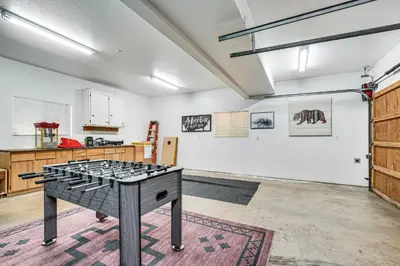 a room with a ping pong table in the middle at Arnold Family Cabin with Hot Tub, Arcade and Deck in Arnold