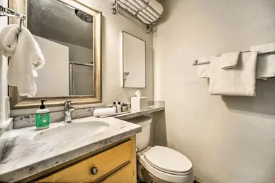a bathroom with a sink and a toilet and a mirror at Walk to Ski Resort Tahoe Donner Studio with Balcony in Truckee