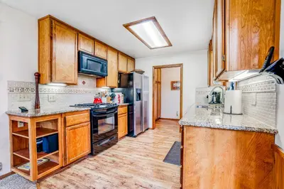 a kitchen with wooden cabinets and stainless steel appliances at Worth The Waite in Arnold