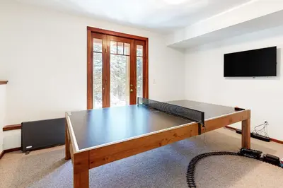 a ping pong table in a room with a tv at Kia Ora Northwoods in Truckee