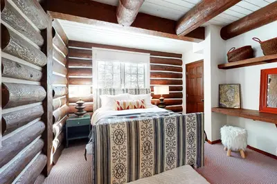 a bedroom with a bed and a wooden wall at Kia Ora Northwoods in Truckee