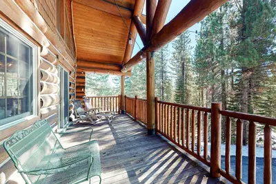 a porch of a cabin with a bench on it at Kia Ora Northwoods in Truckee
