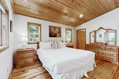 a bedroom with a white bed and a wooden ceiling at Laurelwood Manor in Truckee