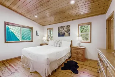 a bedroom with a white bed and a wooden ceiling at Laurelwood Manor in Truckee