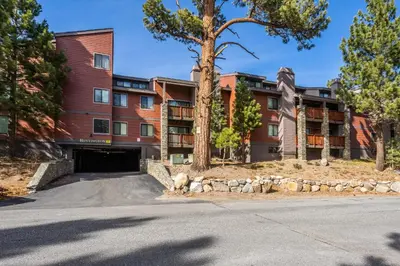 an apartment building with a parking garage in front of it at New Listing Updated 1 bedrm 1 bath Summit H Building #95 condo Just steps to Eagle Lodge sleeps 4 in Mammoth Lakes