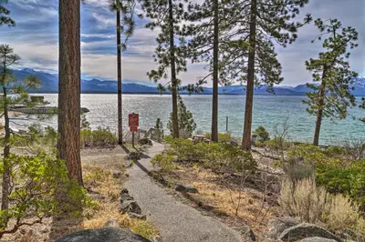 a path along the shore of a lake with trees at Deck and Beach Access Lake Tahoe Shoreside Retreat! in Elk Point