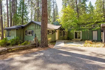 a green house in the middle of a forest at Cedar Nest in Wawona