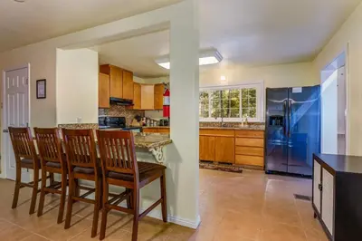 a kitchen with a table and chairs and a refrigerator at Cedar Nest in Wawona