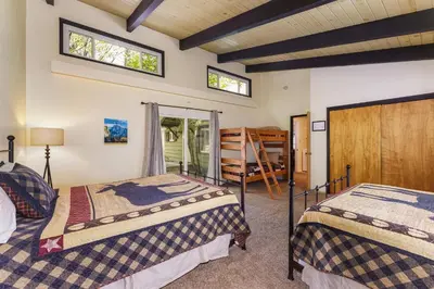 two beds in a room with two windows at Cedar Nest in Wawona