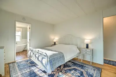 a bedroom with a white bed and a bath tub at Bethel Island Sanctuary with Dock and Boathouse in Oakley