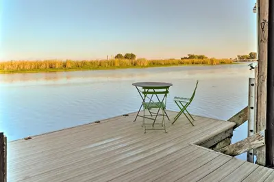 a table and two chairs sitting on a dock near the water at Bethel Island Sanctuary with Dock and Boathouse in Oakley