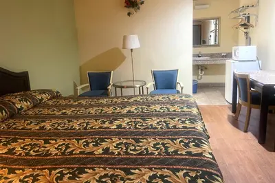 a hotel room with a bed and a table and chairs at Sunstar Inn Los Banos near I-5 in Los Banos