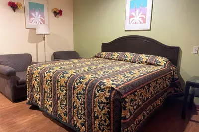 a bedroom with a bed with a blanket on it at Sunstar Inn Los Banos near I-5 in Los Banos