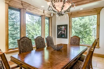 a dining room with a table and chairs and windows at Alpine Luxury in Zephyr Cove