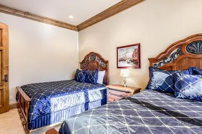 two beds in a bedroom with blue comforter at Alpine Luxury in Zephyr Cove
