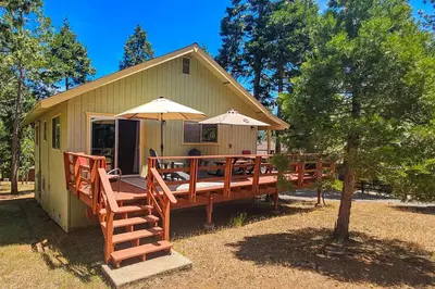a house with a large deck with umbrellas at Redwood Escape in Arnold