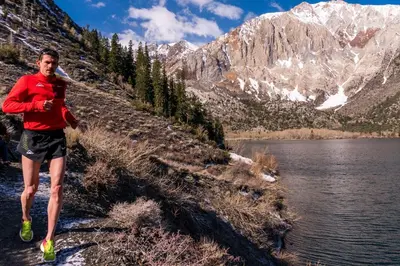 a man running on a trail next to a lake at Three-Bedroom Townhouse in Mammoth Lakes