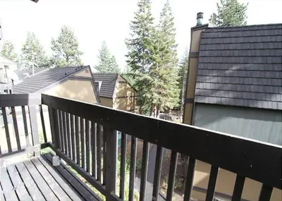 a wooden deck with a fence next to a house at Two-Bedroom Apartment in Mammoth Lakes