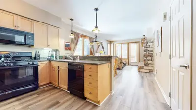 a kitchen with wooden cabinets and a black stove at Mammoth Green #111 condo in Mammoth Lakes