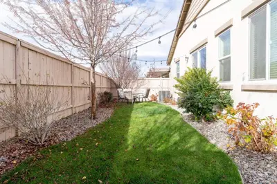a backyard with a fence and green grass at Dream Family Home in South Reno 4 bed 30 Min to Lake Tahoe in Steamboat
