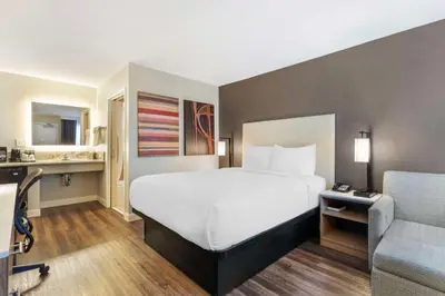 a hotel room with a large bed and a couch at Best Western Plus Rancho Cordova Inn in Rancho Cordova