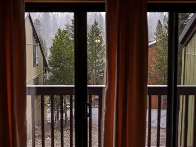 a view from a window of a balcony with trees at COZY Condo at Canyon Lodge! Sleeps 8, a walk to Canyon Lodge in Mammoth Lakes