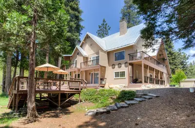 a large house with a porch and a deck at Big Creek Inn in Fish Camp